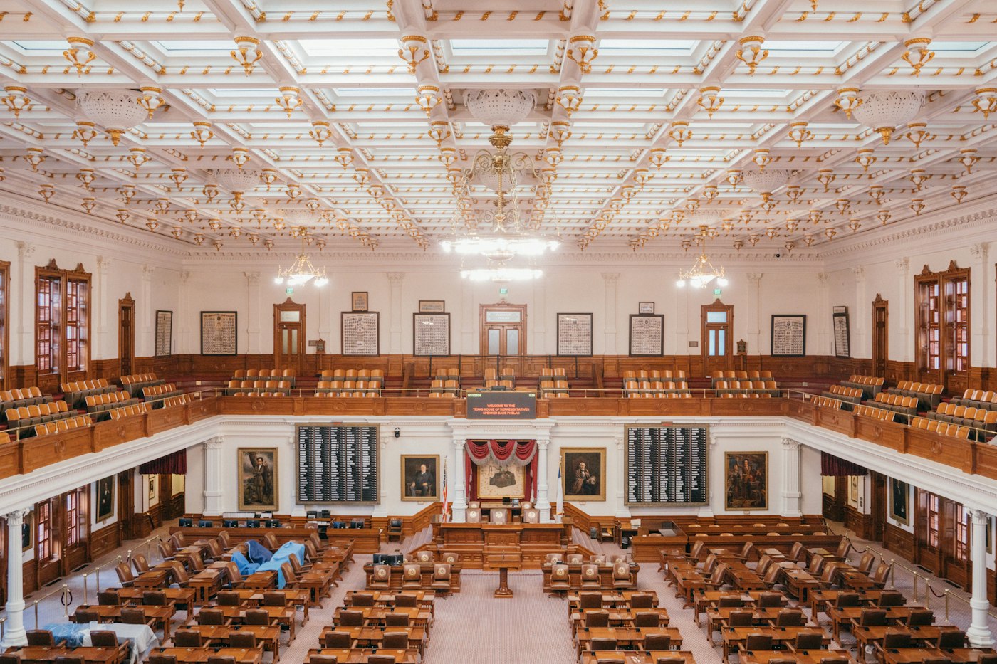 A state house chamber with wooden desks